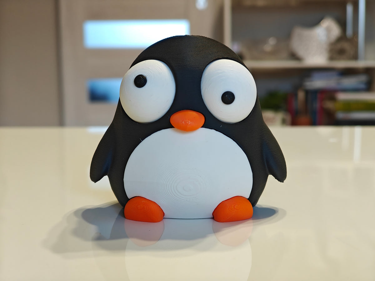 Gek pinguinfiguurtje met beweegbare ogen, close-up op witte achtergrond
