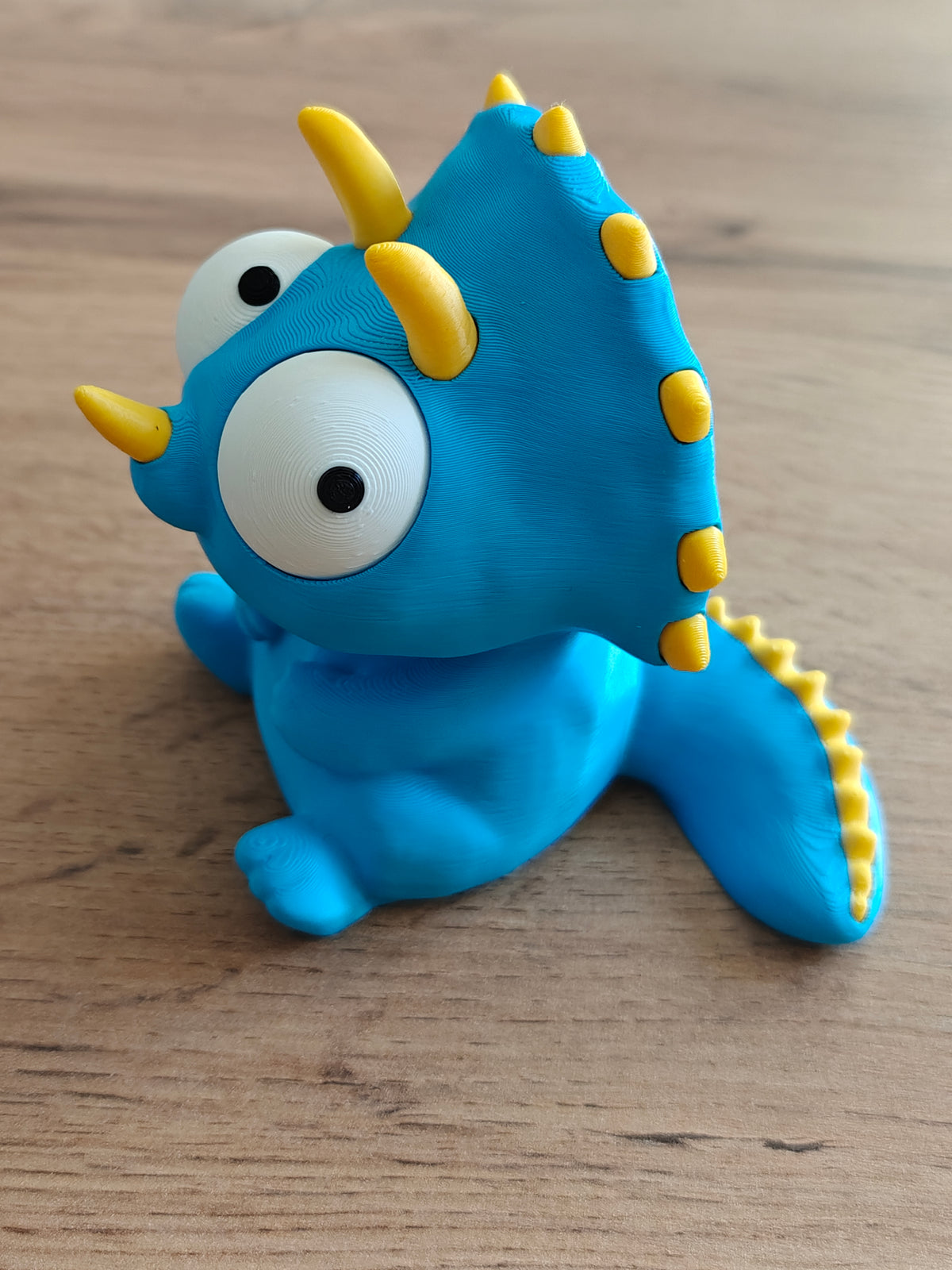 Close-up van beweegbare ogen op gek triceratopsfiguurtje