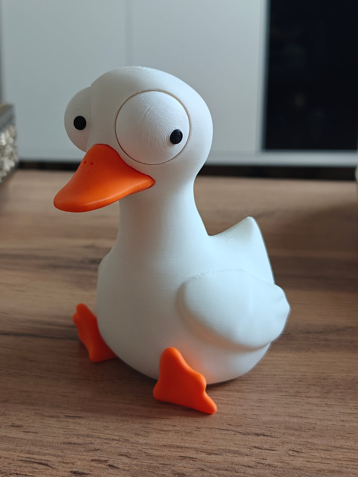 Gek ganzenfiguurtje met grote beweegbare ogen op witte achtergrond