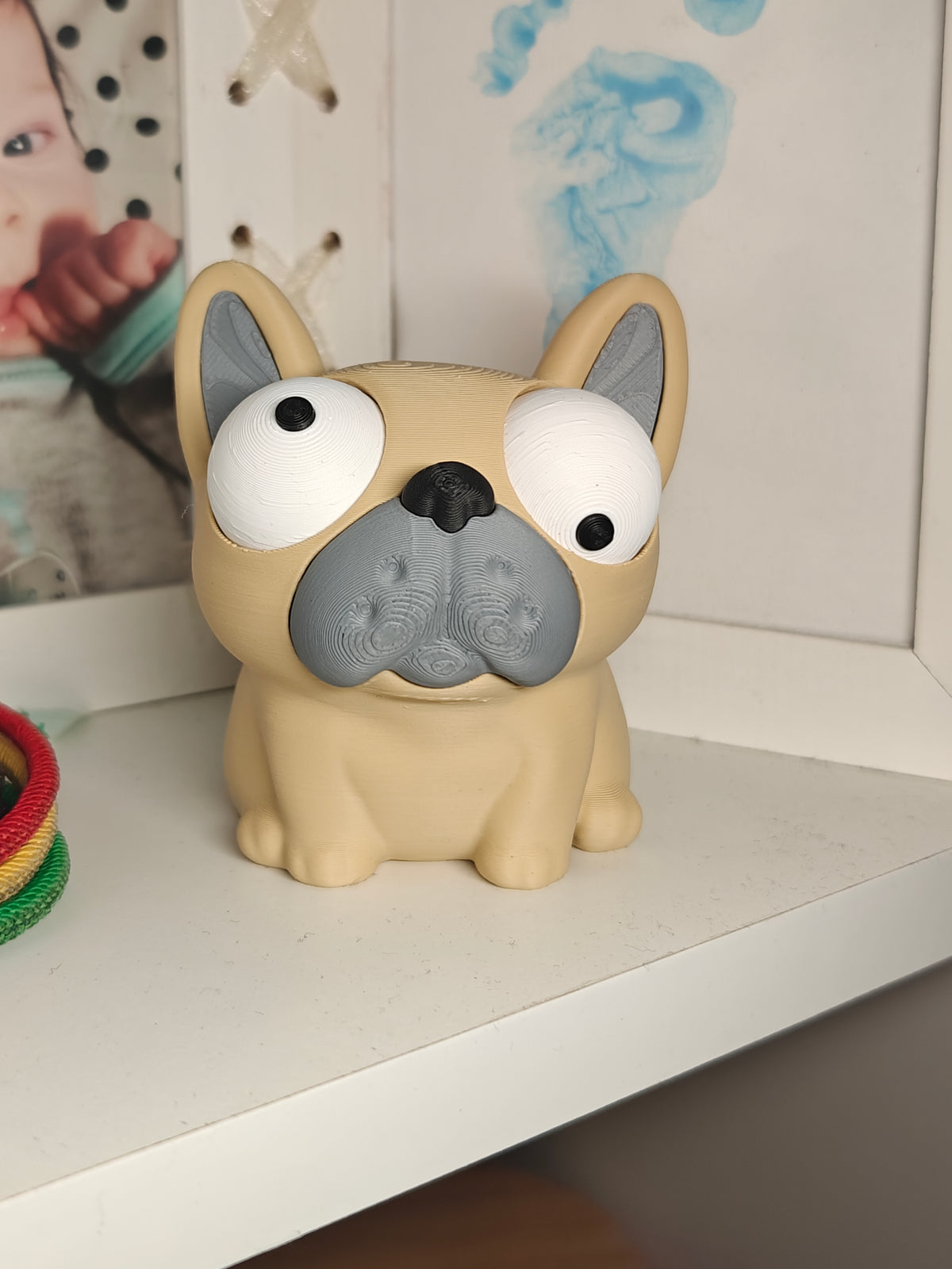 Gek Franse bulldog-figuurtje op bureau naast toetsenbord en plant