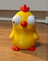 Close-up van een grappig kuikenfiguurtje met grote beweegbare googly eyes op witte achtergrond