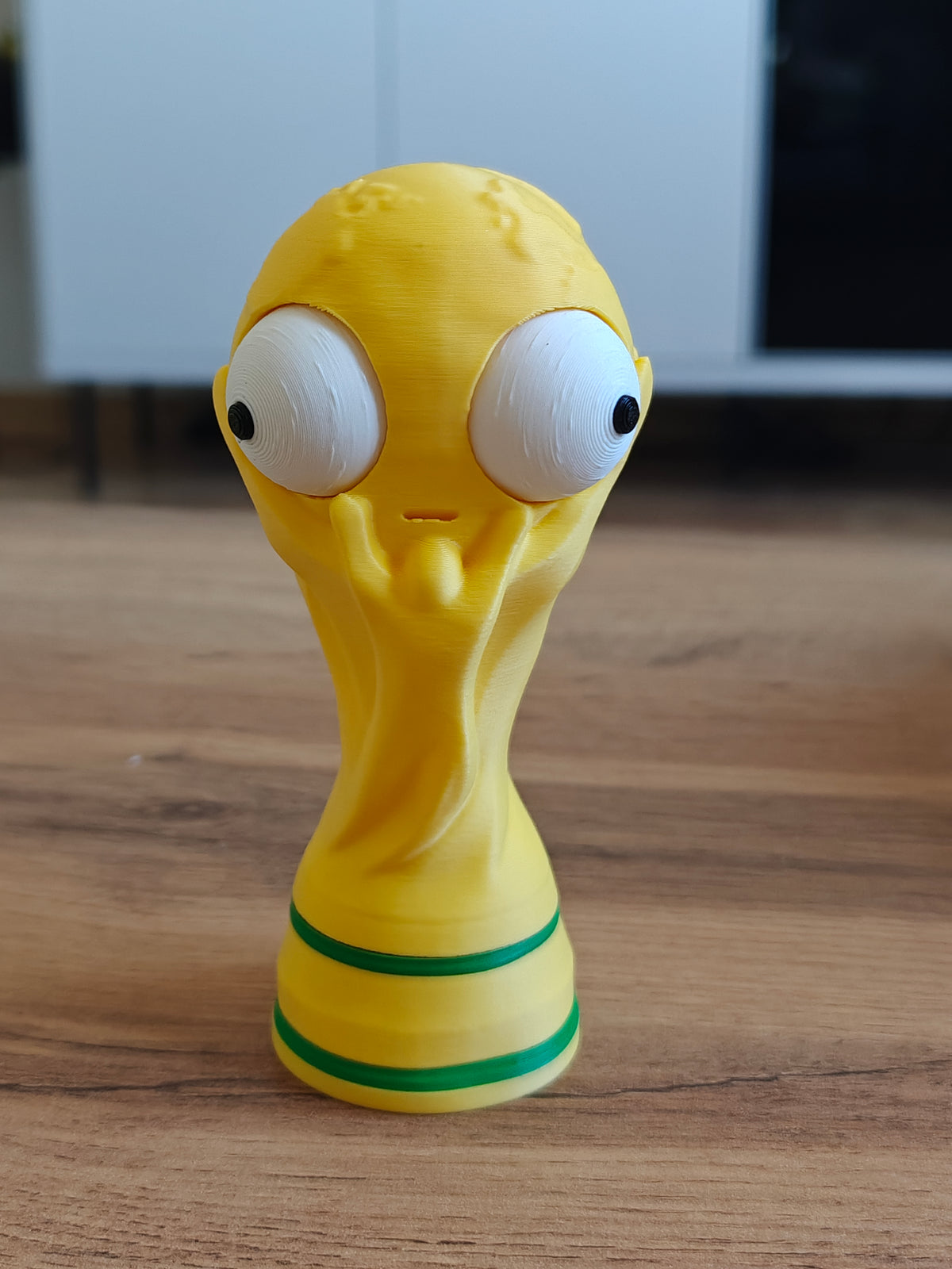Close-up van een grappig WK-bekerfiguurtje met een groot beweegbaar googly eye, vooraanzicht