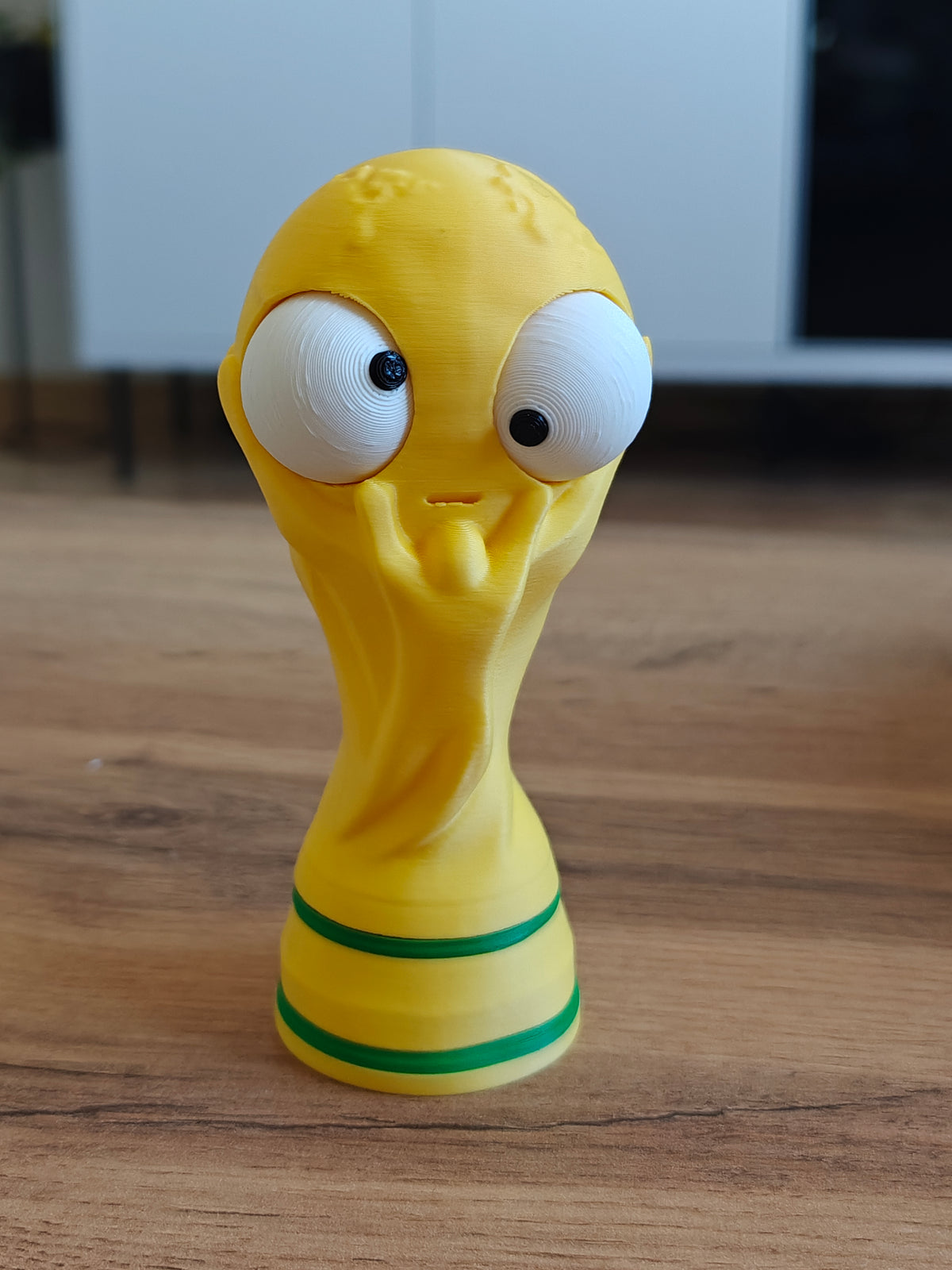Close-up van een grappig WK-bekerfiguurtje met een groot beweegbaar googly eye, vooraanzicht