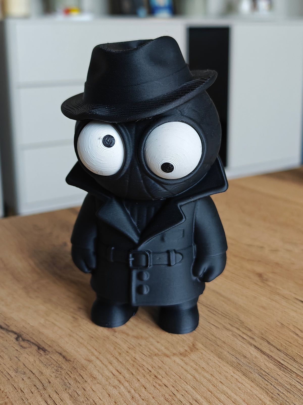 Spider Noir-figuurtje met beweegbare ogen, donkere jas en hoed, close-up op witte achtergrond