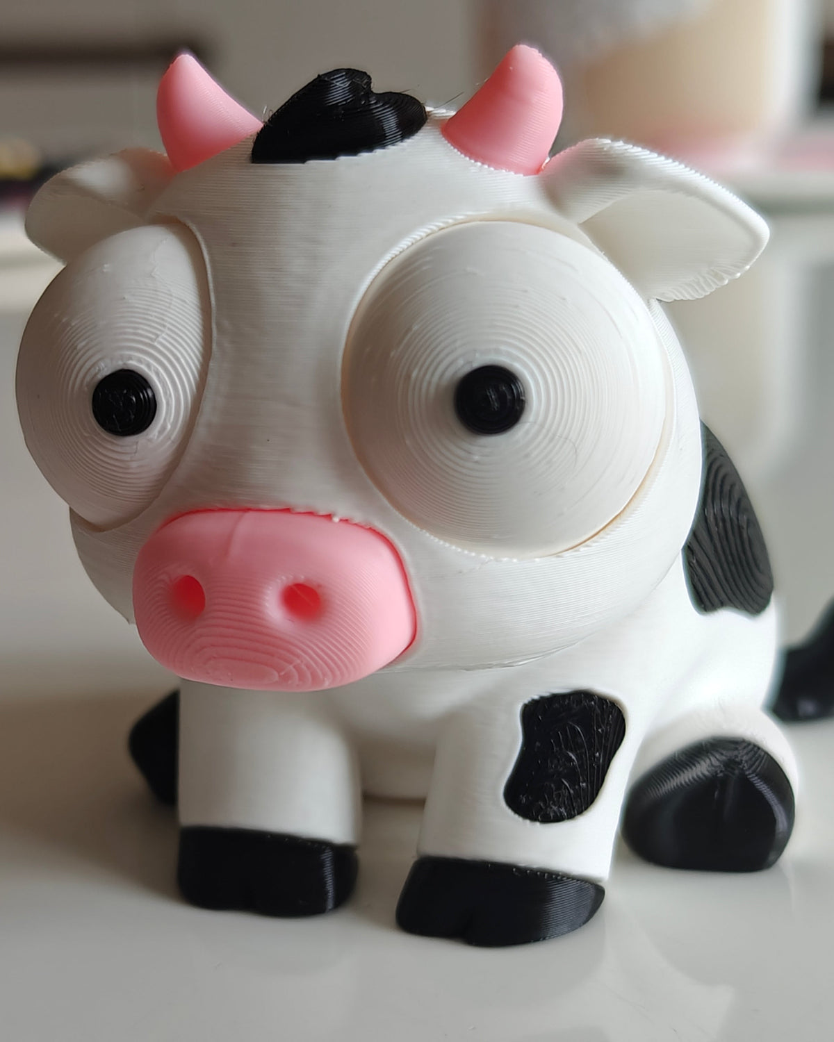 Close-up van een grappig wit-zwart koeienfiguurtje met grote beweegbare googly eyes