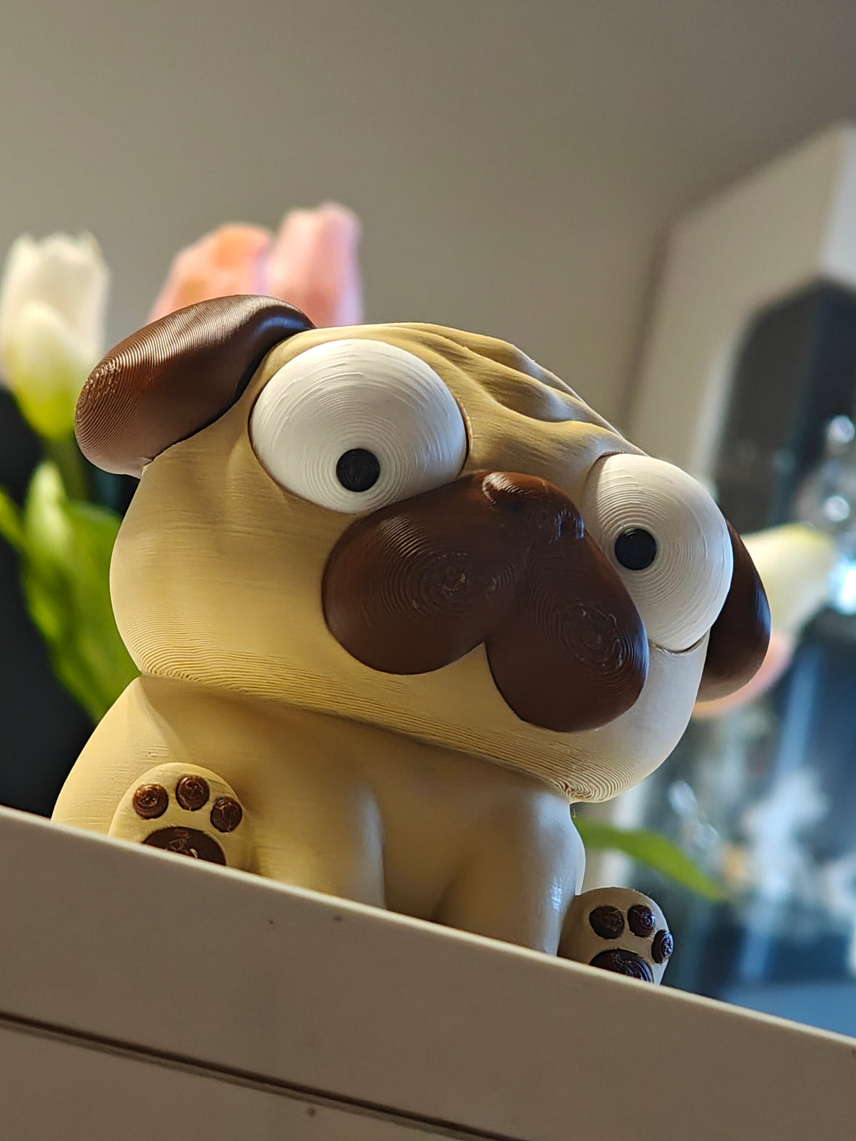Mopsfiguurtje met wiebeloogjes op witte achtergrond – Puggy-bureauspeeltje