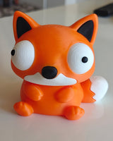 Foxie-vossenfiguurtje op bureau naast plant en koffiemok