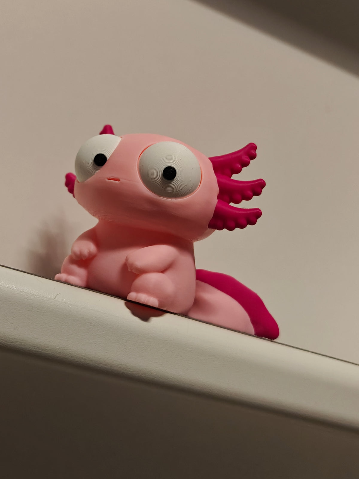 Gek axolotlfiguurtje met grote beweegbare ogen, van voren gezien