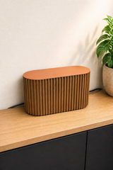 Beige kabelbox met verticale ribbels op witte achtergrond
