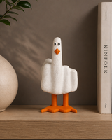 Decoratief ganzenfiguurtje op een plank met boeken en een vaas op de achtergrond