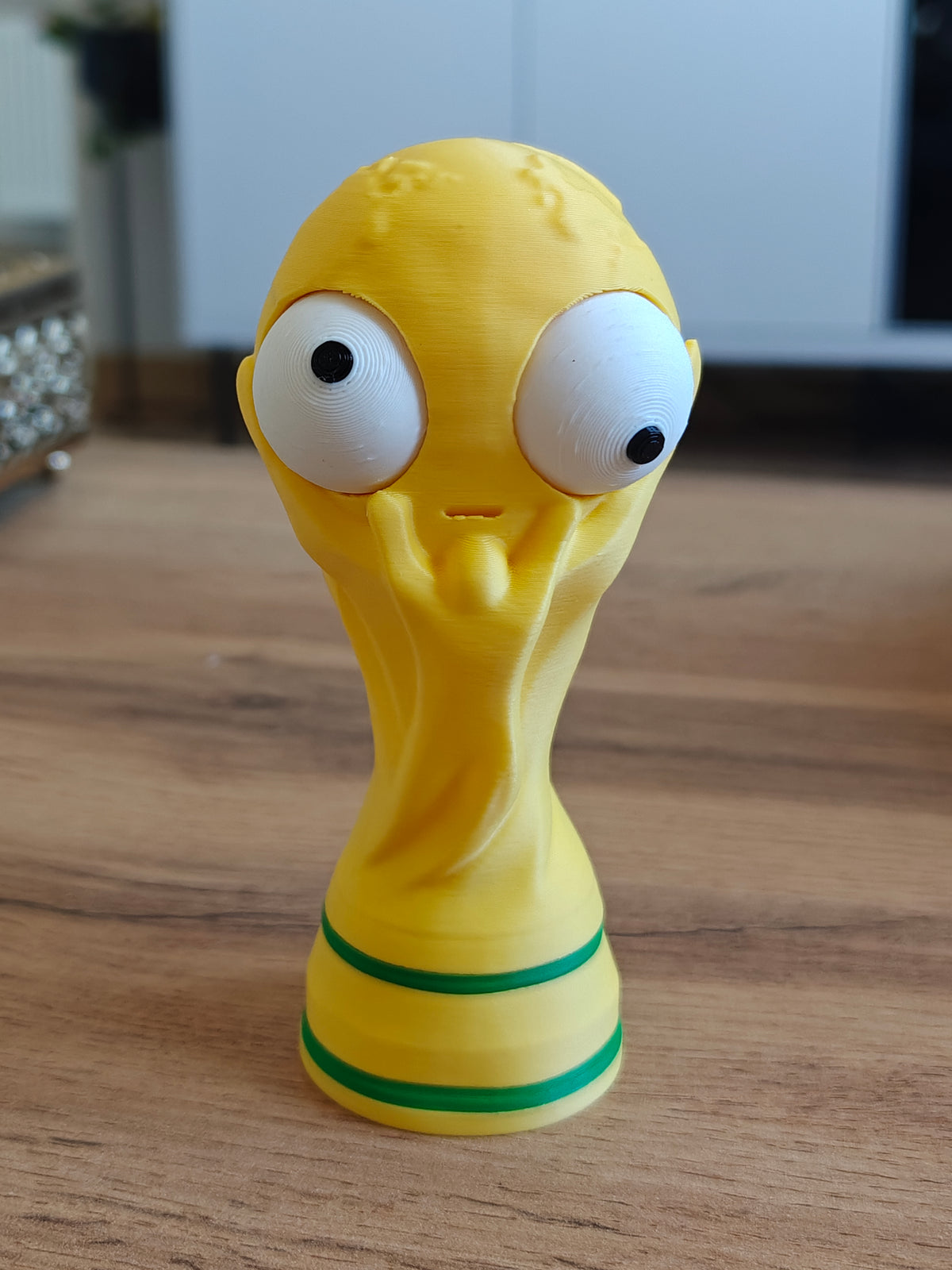 Close-up van een grappig WK-bekerfiguurtje met een groot beweegbaar googly eye, vooraanzicht