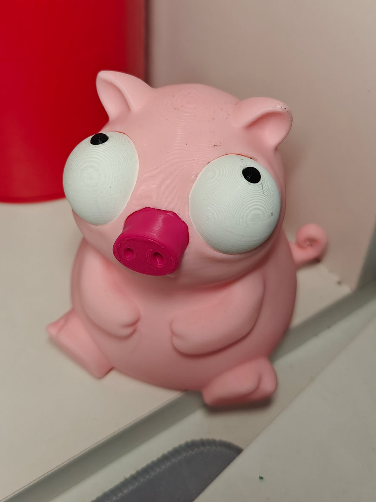 Close-up van een varkensfiguur uit de Goofy-serie met grote beweegbare googly eyes