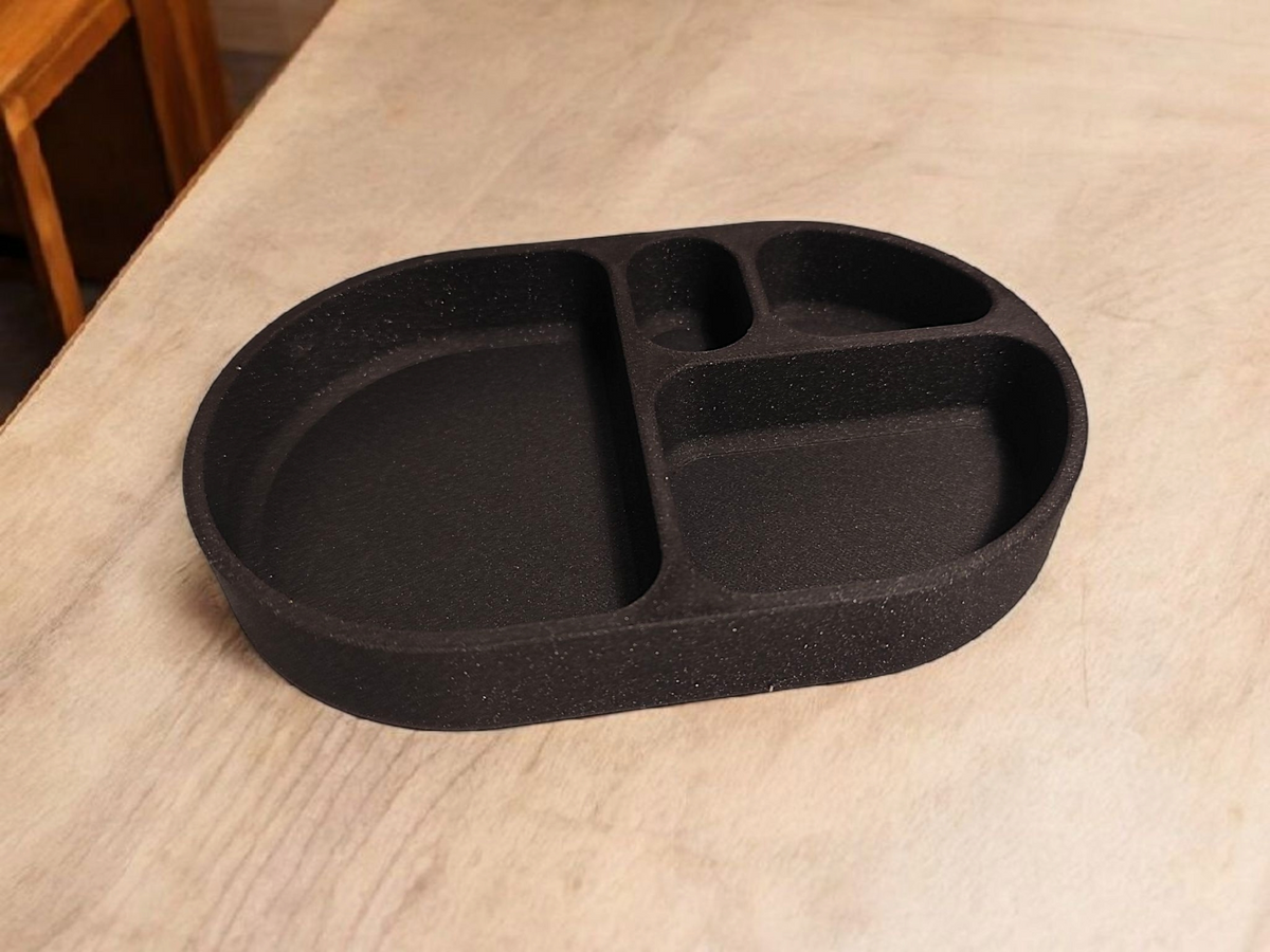 Minimalistisch afgerond sleutelbakje op een witte plank in de hal met sleutels en munten
