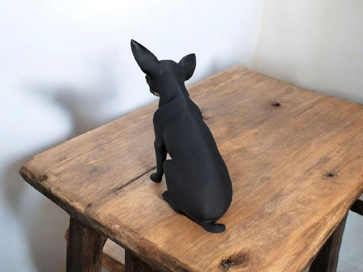 Close-up van een minimalistisch chihuahuabeeld met strak profiel en alerte houding