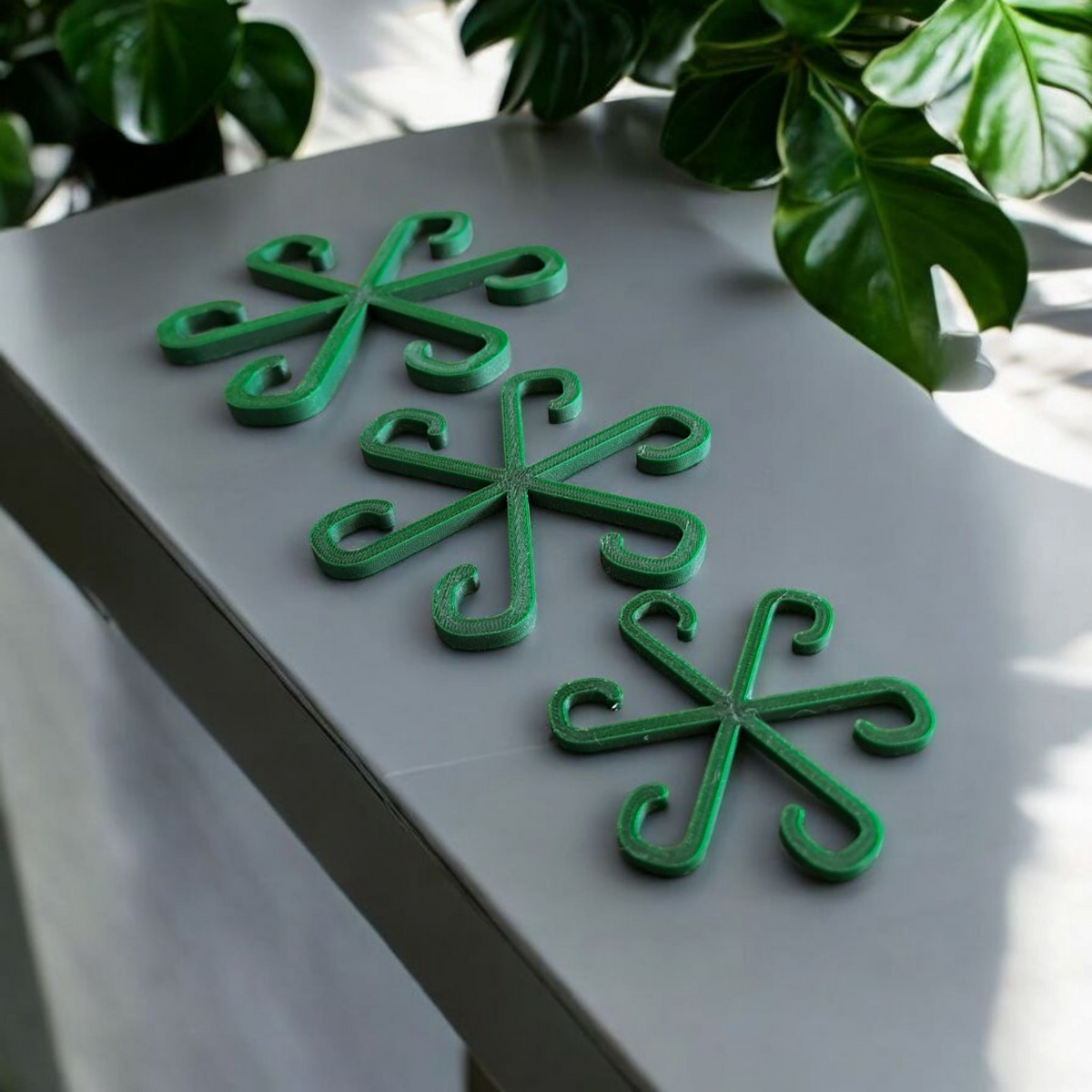 Drie plantensteunhaken in potplanten in een lichte vensterbank