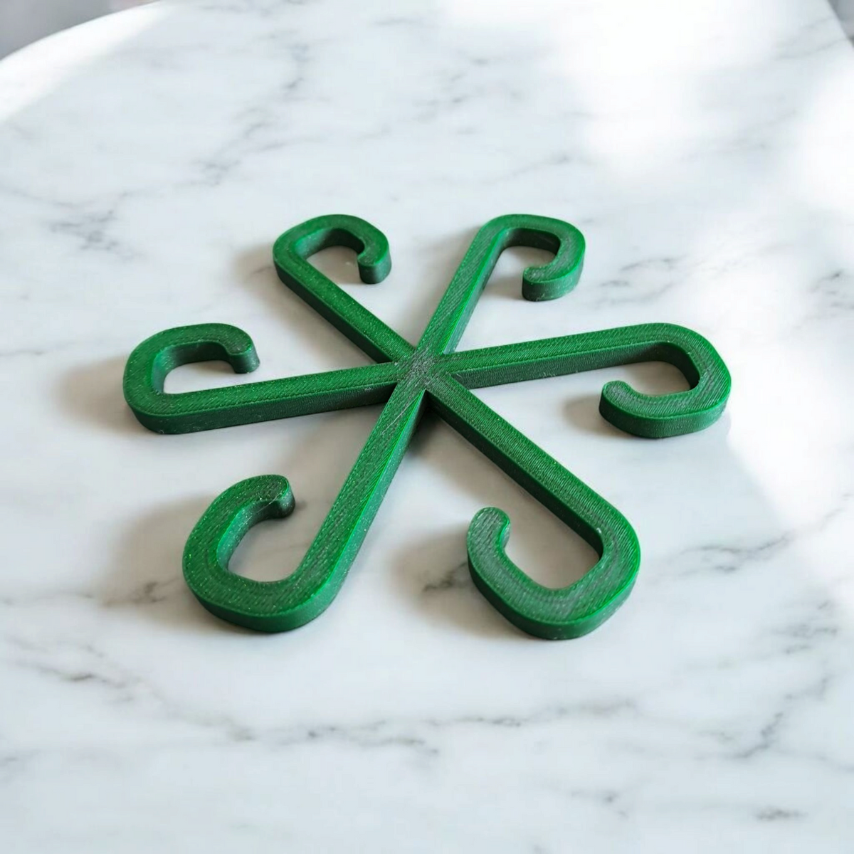 Close-up van een minimalistische plantensteunhaak in een neutrale kleur op witte achtergrond