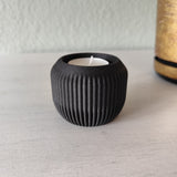 Minimalistische theelichthouder met brandend led-theelichtje op een houten plank