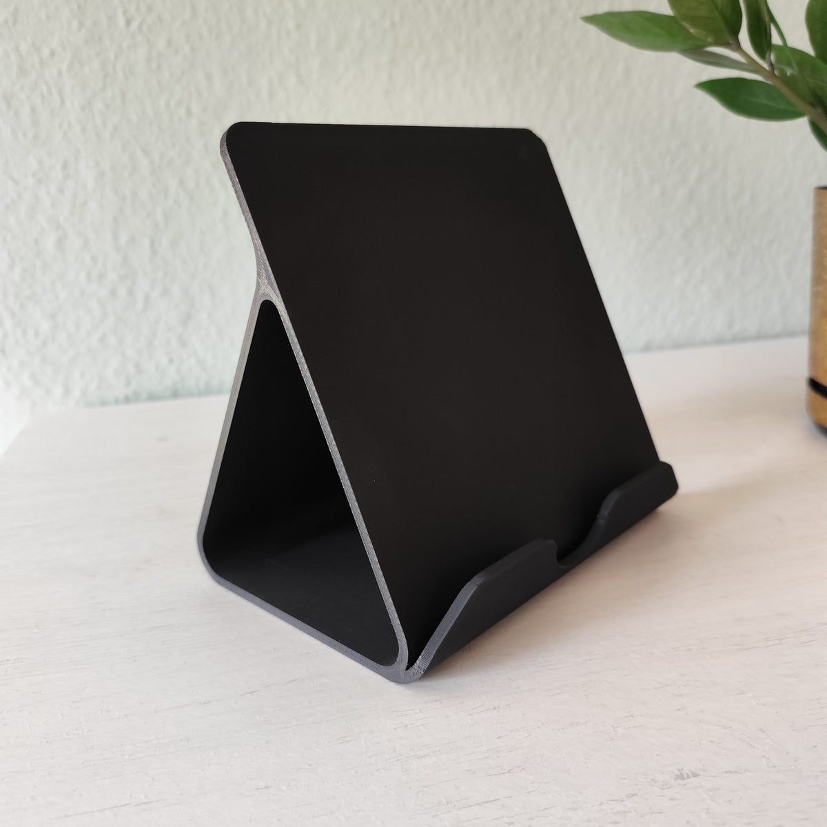 Tablet in iPad-standaard op een opgeruimd bureau bij kantoorbenodigdheden