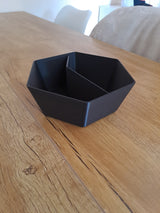 Pistacheschaal met twee vakken op een houten oppervlak met verspreide noten en doppen