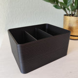 Geribbelde afstandsbedieningshouder op een houten salontafel met afstandsbedieningen erin