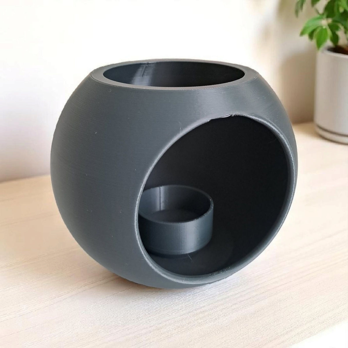 Bolvormige led-theelichthouder in wit, close-up van de gladde geometrische vorm