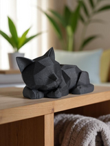 Schattig low-poly katjesfiguurtje op een houten plank met planten