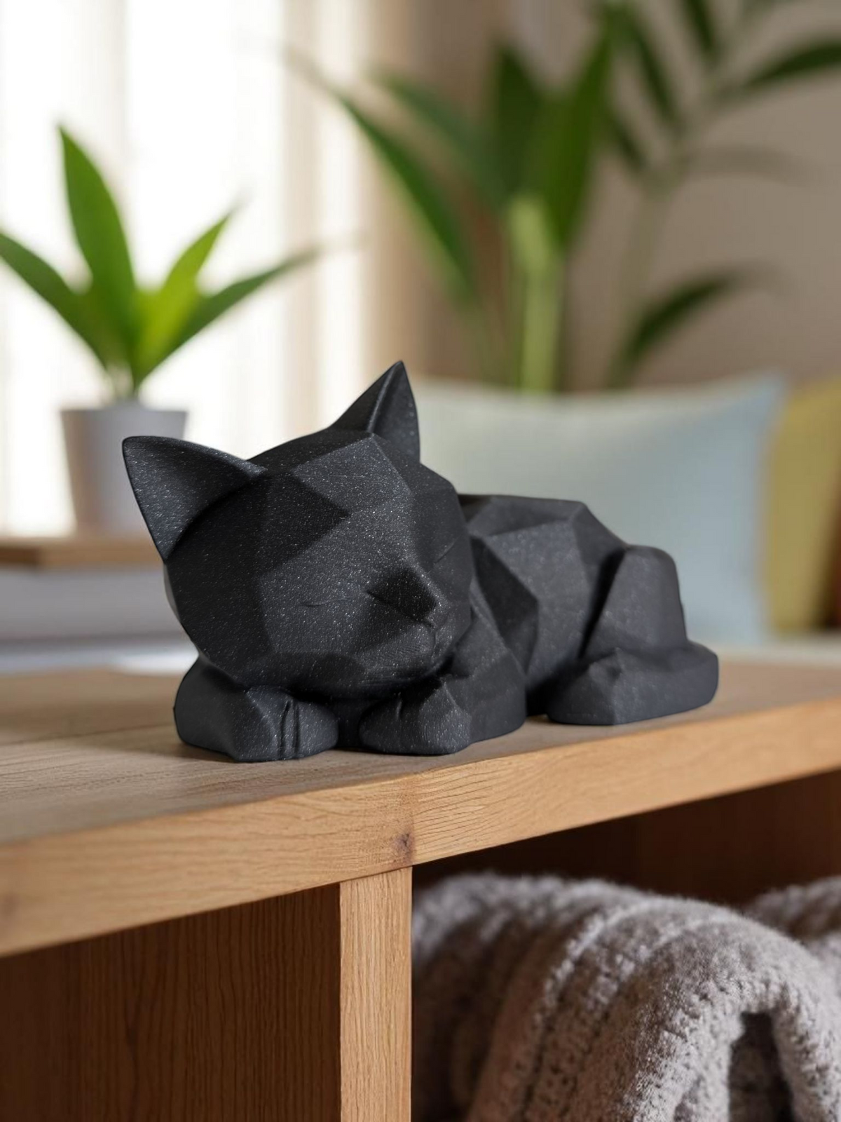 Schattig low-poly katjesfiguurtje op een houten plank met planten