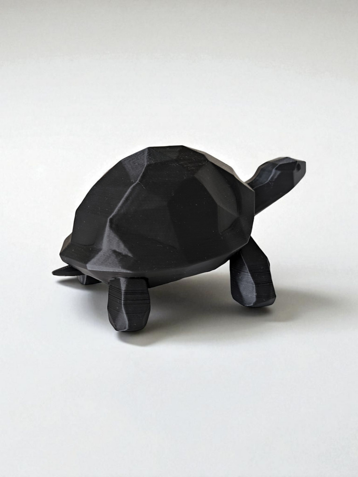 Close-up van een low-poly schildpadbeeld met gefacetteerd oppervlak en strakke lijnen