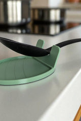 Witte lepelhouder met een houten lepel, close-up van de gebogen rand