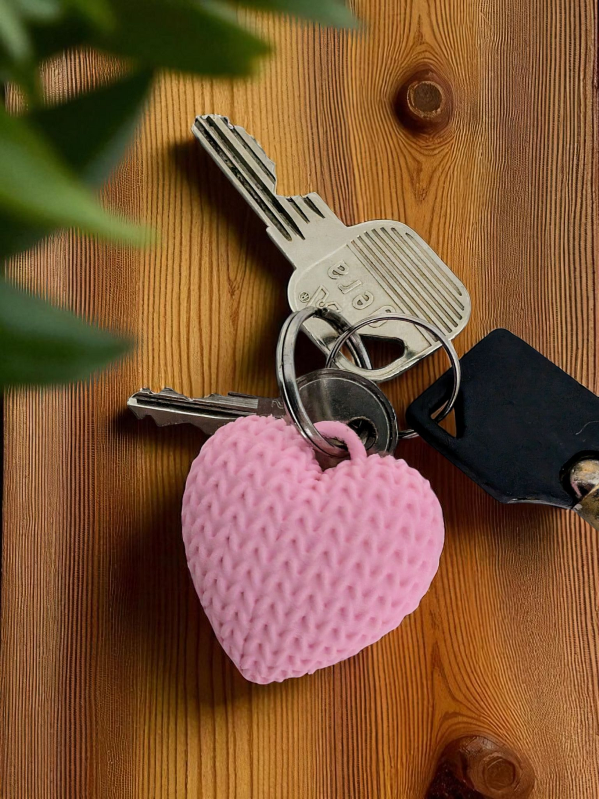 Gebreide hartjessleutelhanger aan een sleutelbos in neutrale kleuren