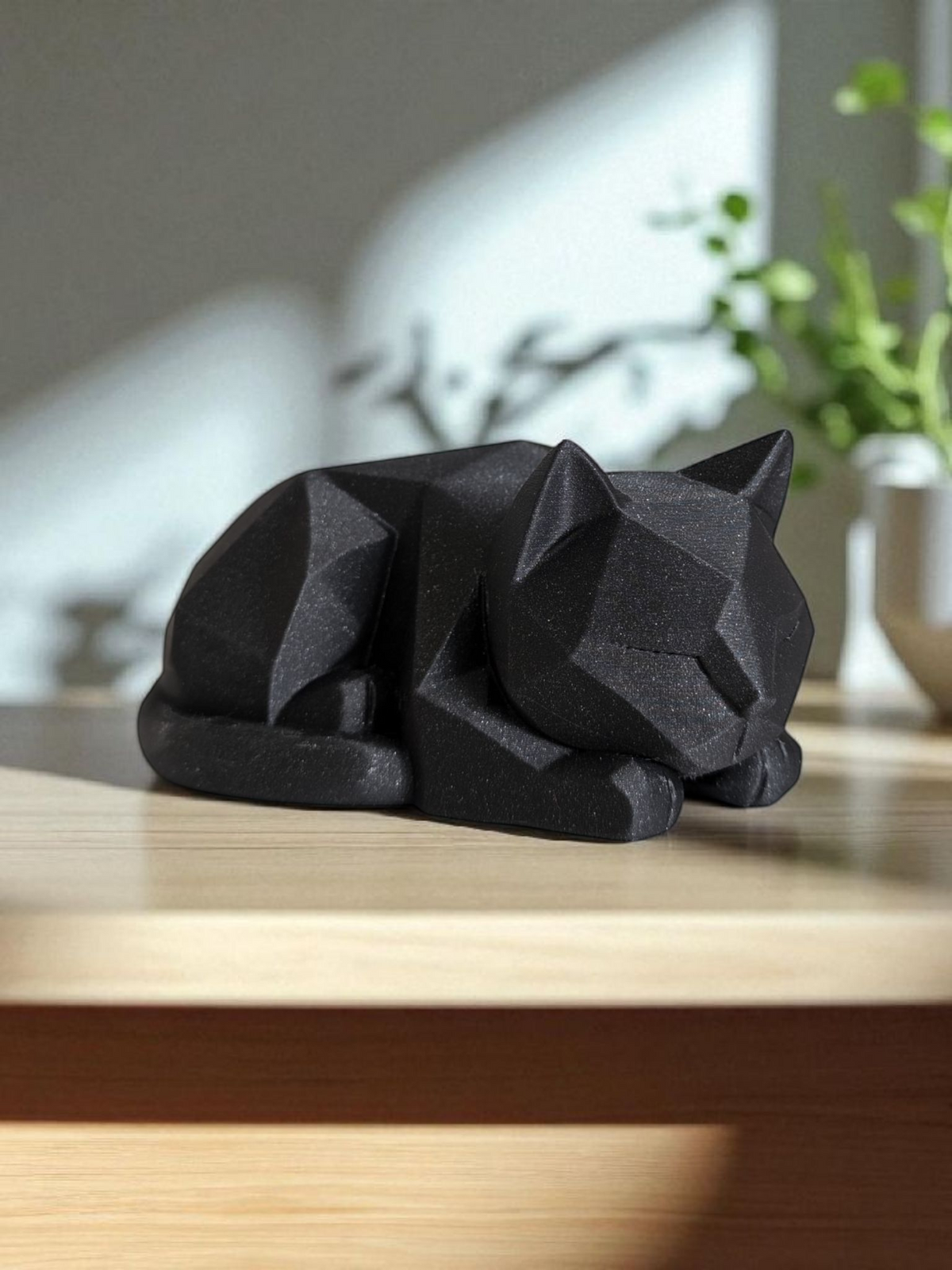 Low poly kittenfiguurtje op een houten bureau met minimalistische styling