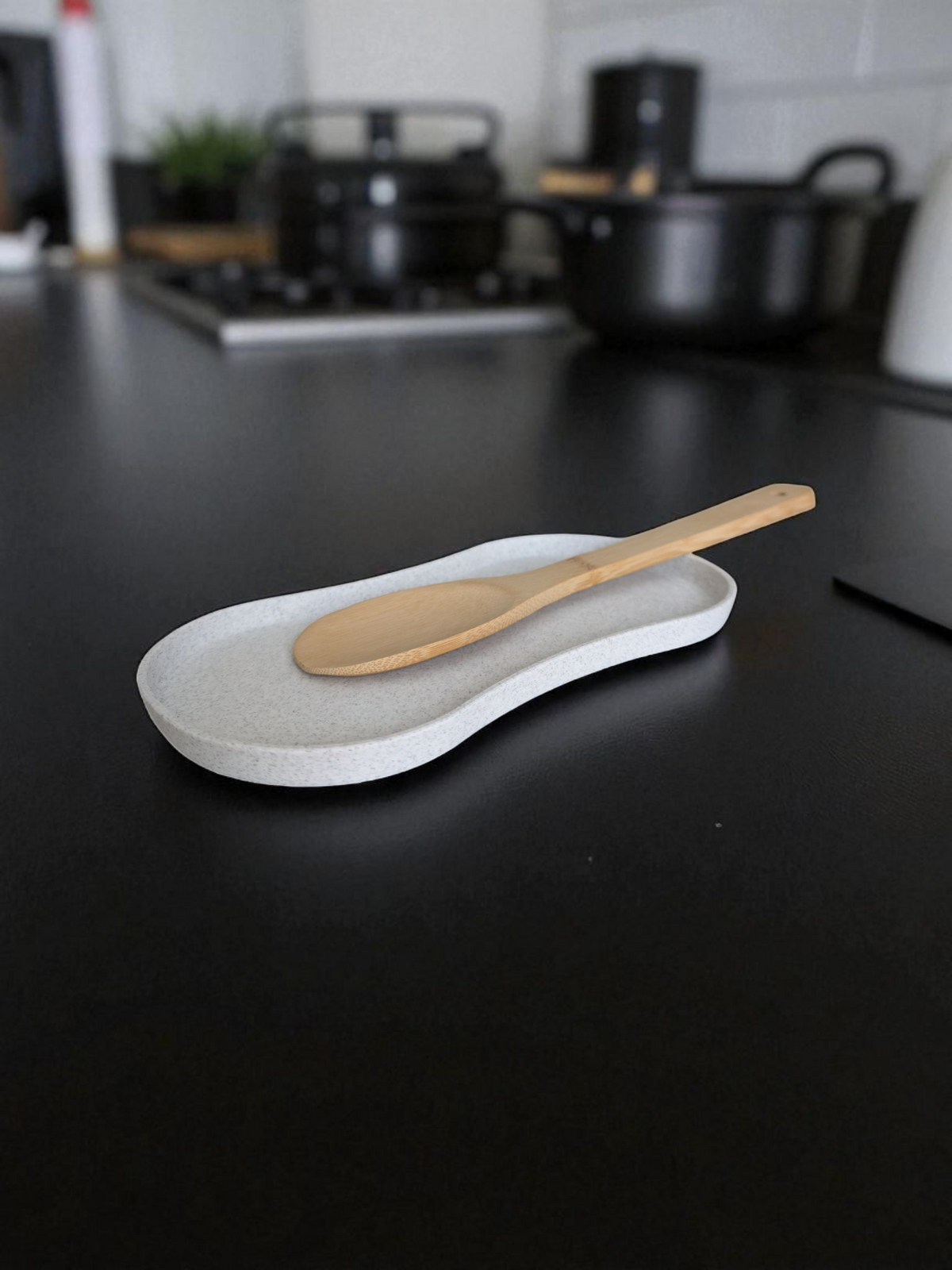 Lepelhouder op het aanrecht met een houten spatel en een pollepel