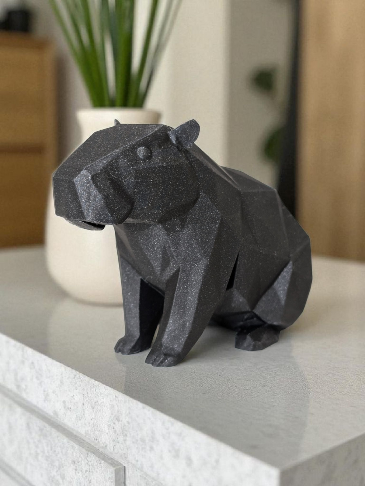 Minimalistisch capibarafiguurtje op een witte plank in een lichte kamer