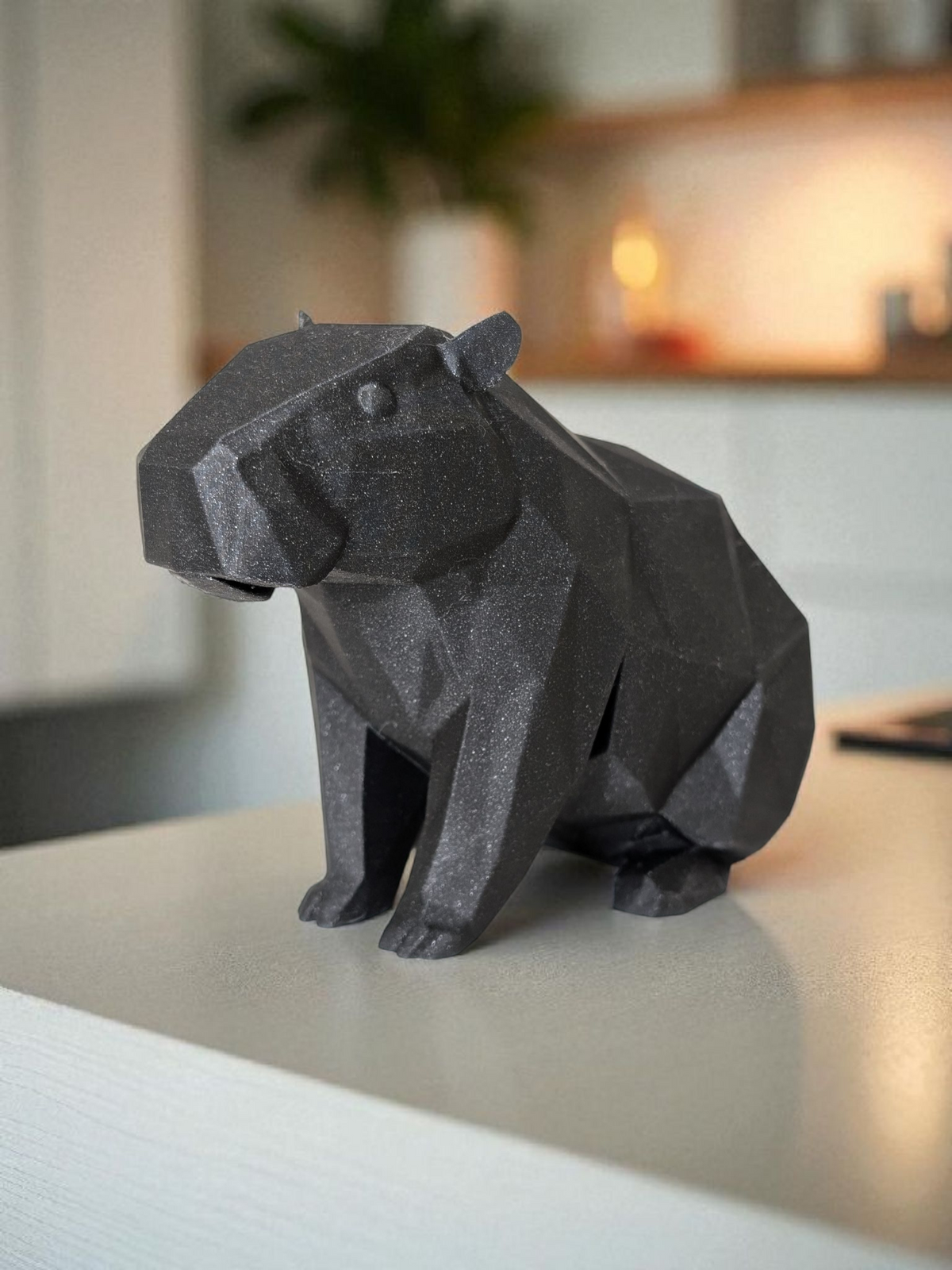 Low poly capibarasculptuur met geometrisch gefacetteerd oppervlak en rustige houding