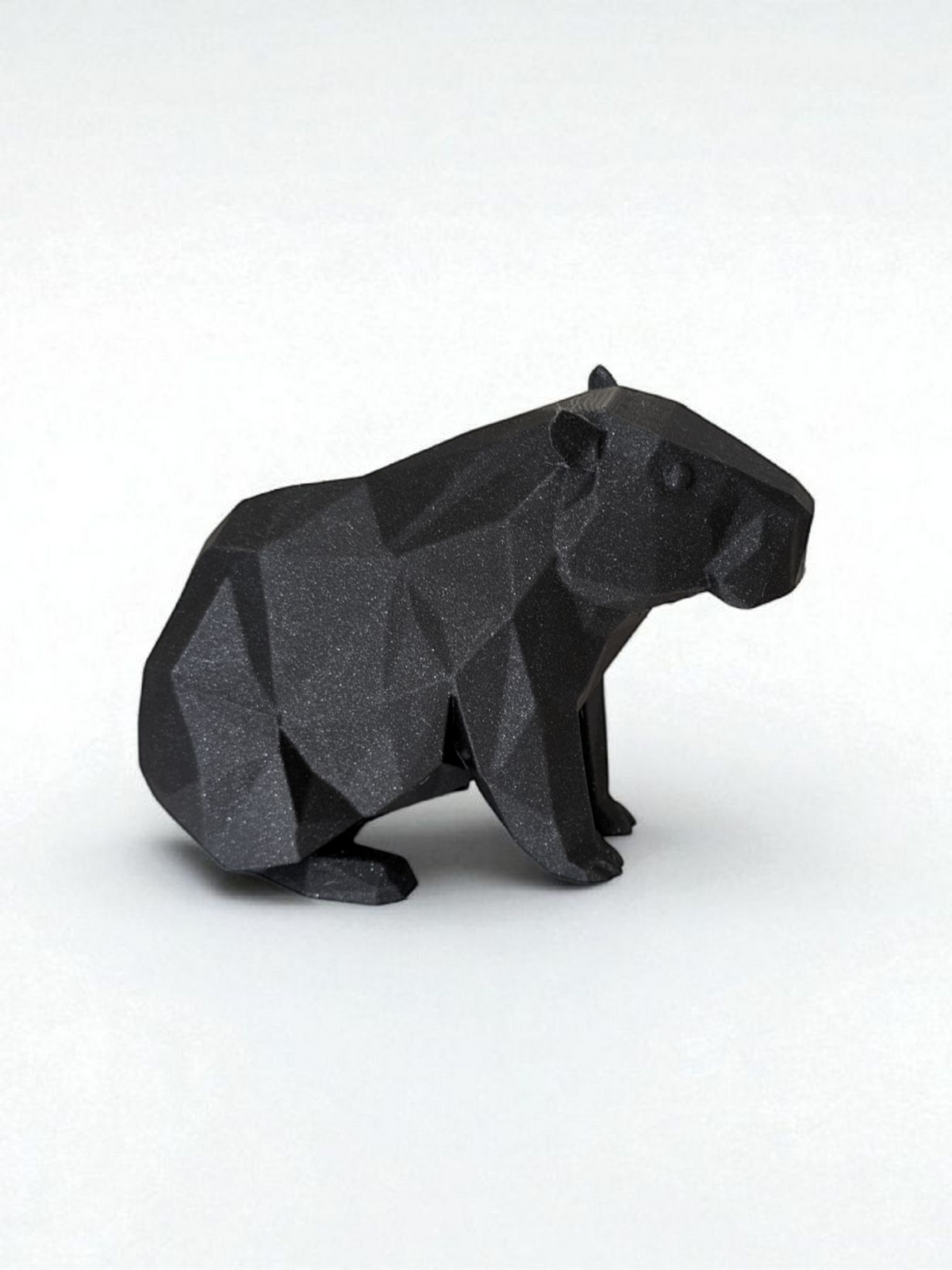 Low poly capibarasculptuur met geometrisch gefacetteerd oppervlak en rustige houding