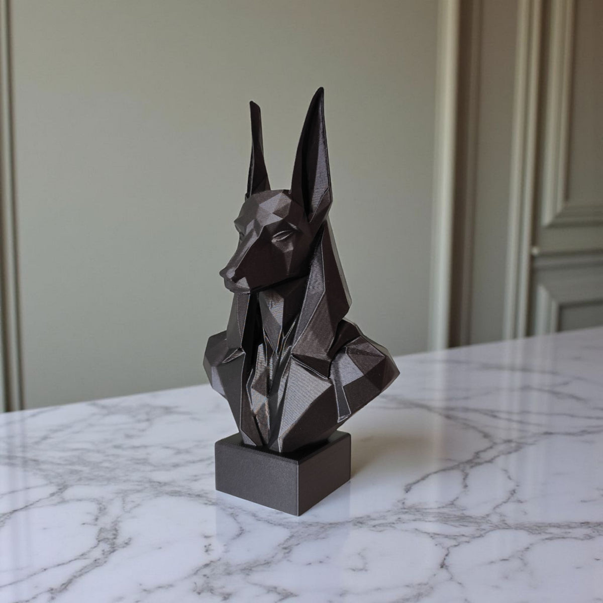Close-up van een low-poly Anubis-buste met gefacetteerde geometrische vlakken