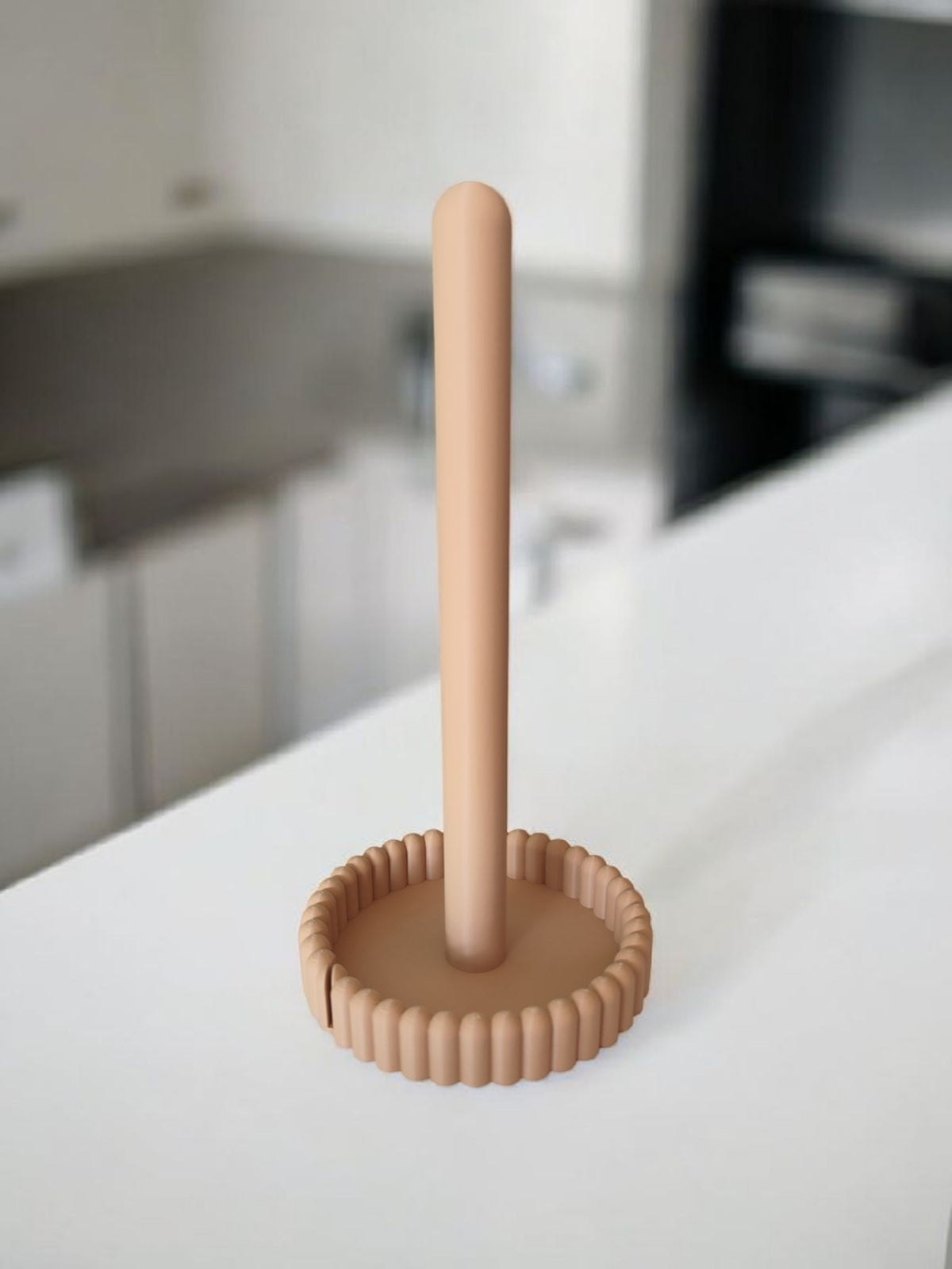 Keukenrolhouder op het aanrecht naast een witte koffiekop en een groene plant