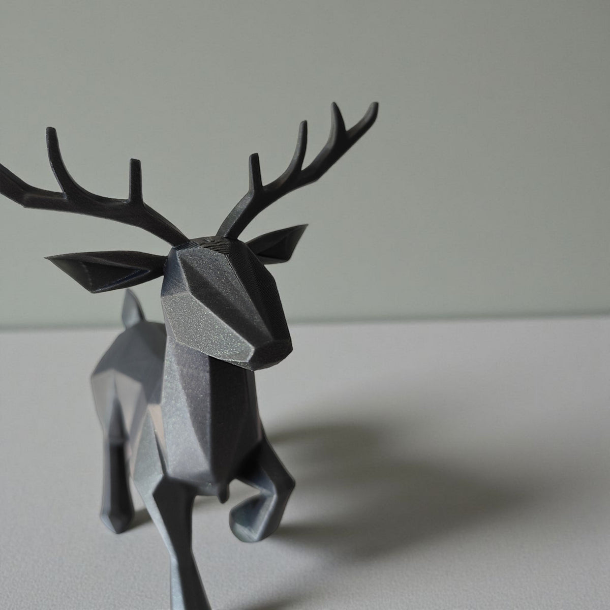 Close-up van een minimalistisch low-poly rendier met gefacetteerd oppervlak en gewei