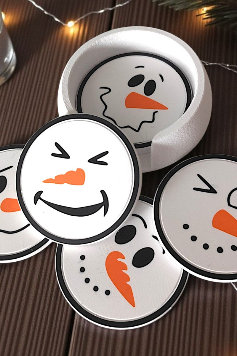 Zes onderzetters met sneeuwpoppen met verschillende gezichten in bijpassende houder