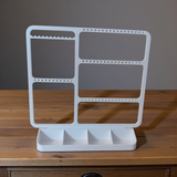 Minimalistische sieradenhouder met oorbellen, ringen en kettingen in strak wit design
