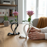 Minimalistische reageerbuisvaas met een enkele groene stengel in een Scandinavisch interieur