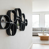 Drie modulaire ronde plankjes verticaal aan een witte muur met kleine voorwerpen