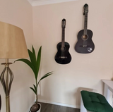 Elektrische gitaar aan witte wand in subtiele minimalistische houder