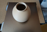 Close-up van een minimalistische ronde vaas met gladde bolvorm