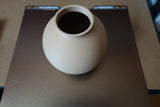Close-up van een minimalistische ronde vaas met gladde bolvorm
