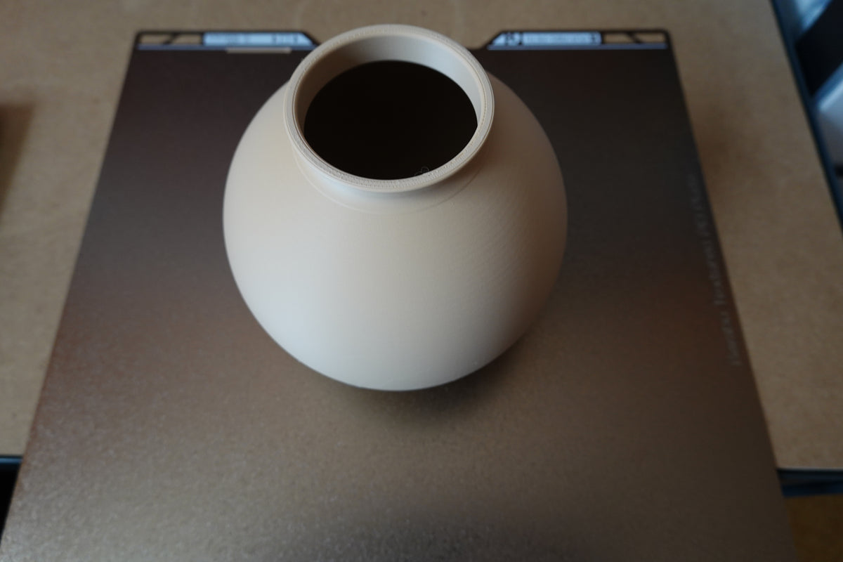 Close-up van een minimalistische ronde vaas met gladde bolvorm