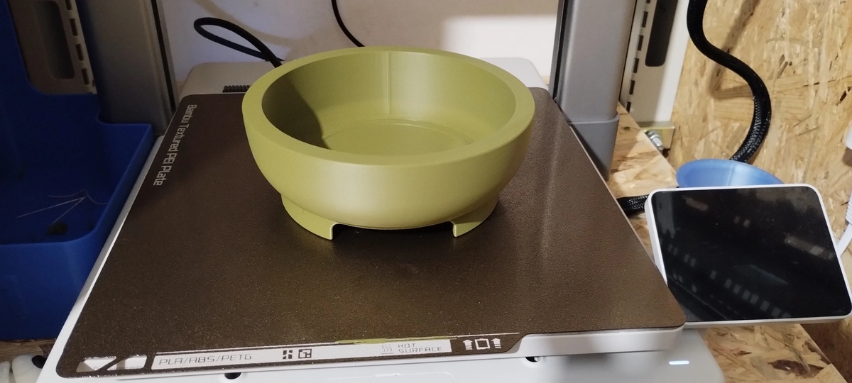 Ronde bonsaipot op een houten plank met een plantje