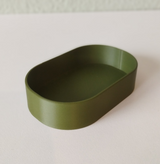 Minimalistisch rond sleutelbakje in een zachte neutrale kleur, close-up van het gladde, vlakke oppervlak
