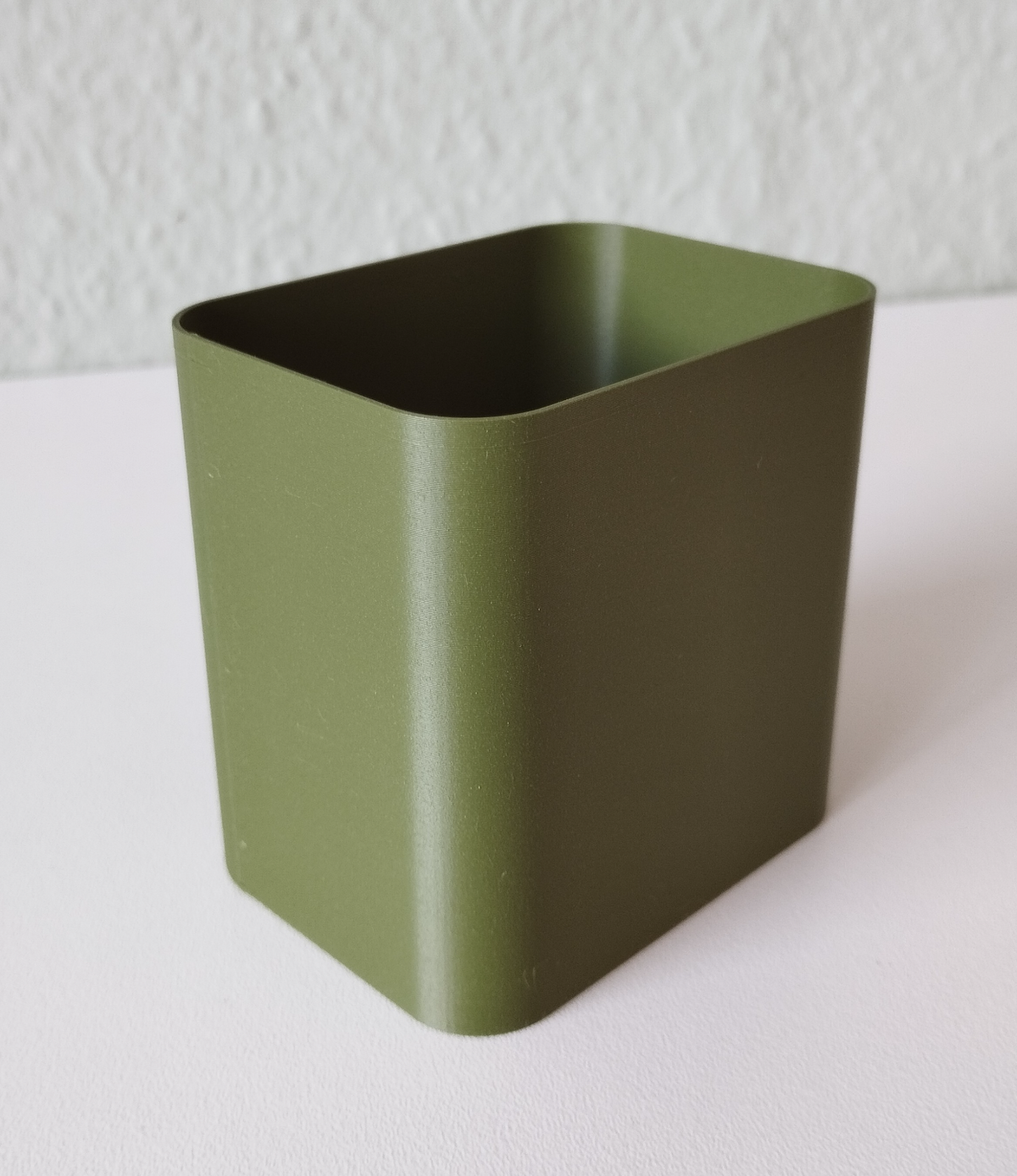 Minimalistische pennenhouder op een bureau met balpennen en notitieboekjes