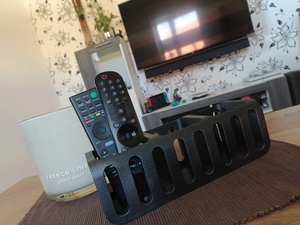 Afstandsbedieningshouder op een bijzettafel in de woonkamer naast een plant